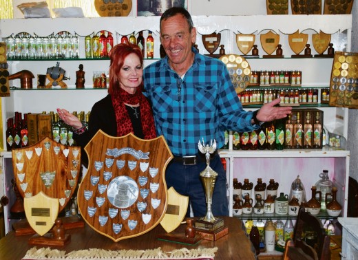 Boet en sy vrou Martie wys na die verskeidenheid bottels mampoer en likeurs en van die toekennings wat hulle al gewen het. Foto: Dustin Wetdewich